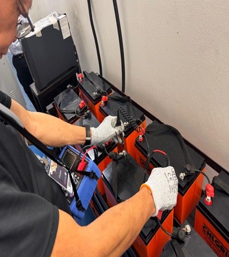 Technician testing and replacing UPS batteries